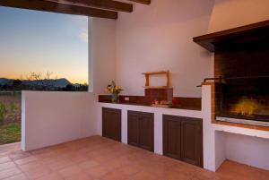 an outdoor kitchen with a fireplace and a view at Villa Maria in Port de Pollensa