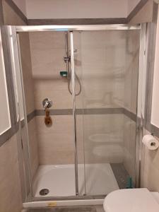 um chuveiro com uma porta de vidro na casa de banho em Egiziaca97 em Nápoles