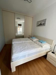 Schlafzimmer mit einem weißen Bett und einem Spiegel in der Unterkunft Central Apartment 10 in Wien