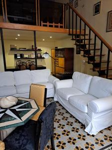 uma sala de estar com um sofá branco e uma escada em Egiziaca97 em Nápoles