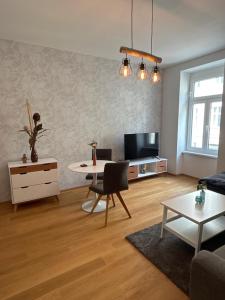 ein Wohnzimmer mit einem Tisch und einem TV in der Unterkunft Central Apartment 10 in Wien