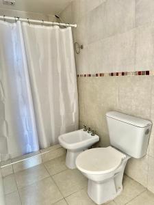 Un baño blanco con inodoro y lavabo. en depto 82, en Cañuelas