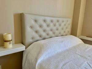 1 dormitorio con 1 cama blanca con manta blanca en Apart 375 CAÑUELAS en Cañuelas