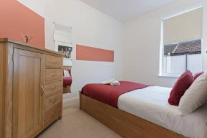 a bedroom with a bed and a dresser and a window at Elton House - Prime Location - Free Parking, Fast WiFi and Smart TV by Yoko Property in Redcar