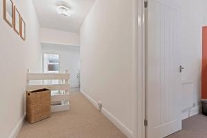a hallway with white walls and a white closet at Elton House - Prime Location - Free Parking, Fast WiFi and Smart TV by Yoko Property in Redcar