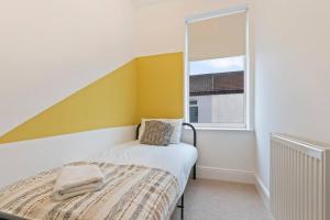 a small bedroom with a bed and a window at Elton House - Prime Location - Free Parking, Fast WiFi and Smart TV by Yoko Property in Redcar