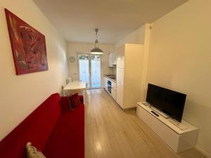 a living room with a red couch and a television at RESIDENCE BIANCOVERDE in Rovereto