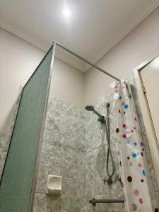 y baño con ducha y cortina de ducha. en Charming Brick Homestay Room in Northam en Northam