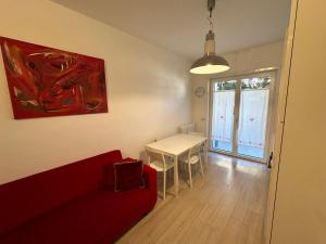 sala de estar con sofá rojo y mesa en RESIDENCE BIANCOVERDE en Rovereto