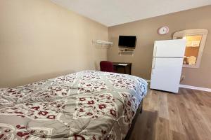 een slaapkamer met een bed en een witte koelkast bij Sparta Seven Motel By OYO near Milledgeville in Sparta