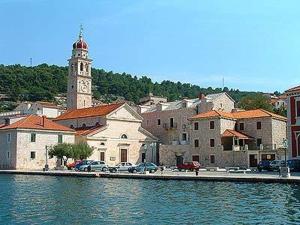 a town with a clock tower and a body of water at Apartment Mireja in Pučišća