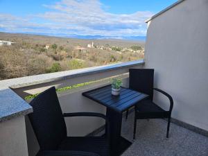 stół i krzesła na balkonie z widokiem w obiekcie Studio Busilak w mieście Vrh