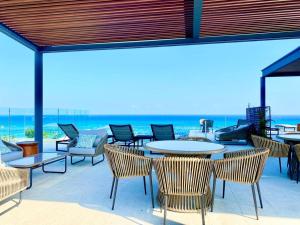 a patio with tables and chairs and the ocean at Marila by Andiani Travel in Playa del Carmen