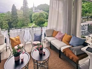 a balcony with couches and tables and a large window at Apartment Vila Pavlovski in Bled +124 photos