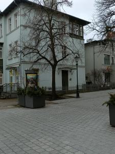 un gran edificio blanco con un árbol delante en So in Sopot Station, en Sopot