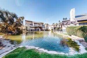 a pool of water in a yard with houses at Lola's Casa Azul #4313 in Palm Springs