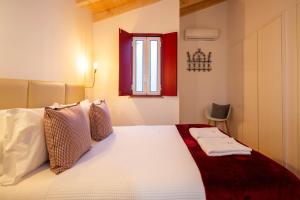 sypialnia z białym łóżkiem i oknem w obiekcie Casinha de Vide - Guest House w mieście Castelo de Vide