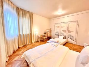 um quarto com 2 camas e uma secretária. em City Center Unirii Square Private rooms with City View - Shared Amenities em Bucareste