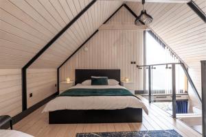 sypialnia z dużym łóżkiem na poddaszu w obiekcie SOWI GAJ - domki całoroczne w Solinie