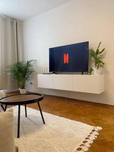 a living room with a tv with a n on it at Útulný byt blízko centra Košíc in Košice