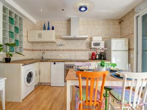 a kitchen with a table and chairs and a sink at Carmen Apartment by Hello Homes Sitges in Sitges +12 photos