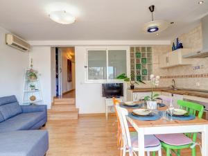 a kitchen and living room with a table and a blue couch at Carmen Apartment by Hello Homes Sitges in Sitges