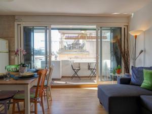 a living room with a couch and a table with a dining room at Carmen Apartment by Hello Homes Sitges in Sitges