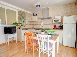 a kitchen with a table and chairs and a white refrigerator at Carmen Apartment by Hello Homes Sitges in Sitges