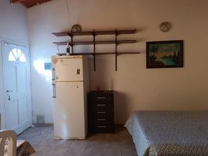 uma cozinha com um frigorífico e uma cama num quarto em Canelo departamento em Ushuaia