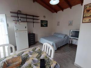 a kitchen with a refrigerator and a table and a bed at Canelo departamento in Ushuaia