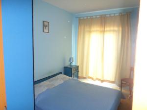 a blue bedroom with a bed and a window at Apartment Mireja in Pučišća