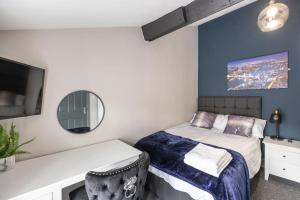 a bedroom with a bed and a mirror at Rugby Coach House, Central location, 5 star rating in Rugby