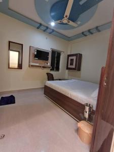 - une chambre avec un lit et un ventilateur de plafond dans l'établissement Hotel Pragati Palace, à Mathura