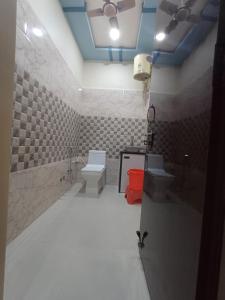 een badkamer met een toilet, een wastafel en een toilet bij Hotel Pragati Palace in Mathura