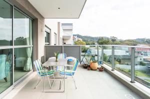 un balcón con mesa y sillas. en Quarto+banheiro+Wi-Fi frente Floripa Shopping, en Florianópolis