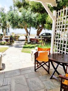 een patio met een tafel, stoelen en bomen bij Villa Anna in ayios Petros