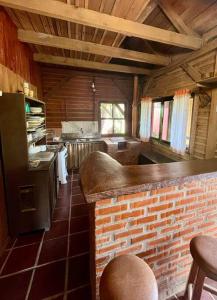 eine Küche mit einer Backsteintheke in einem Zimmer in der Unterkunft Chalé canadense em Rio Bonito in Rio dos Cedros