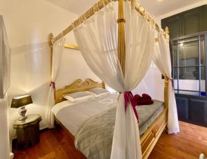 ein Schlafzimmer mit einem Himmelbett mit weißen Vorhängen in der Unterkunft La Maison des Templiers ~ Ostal Médiéval ~ Logis enchantés in Carcassonne + 42 Fotos