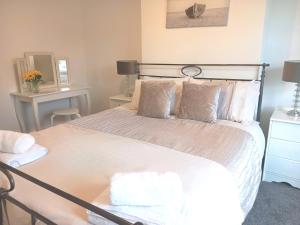 a bedroom with a large bed with white sheets and pillows at Coquet Nest AMBLE in Amble +7 photos