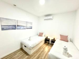 um quarto com duas camas e uma mesa em Apartamentos Madrid Connection - Universidad by Oshun Apartments em Madri