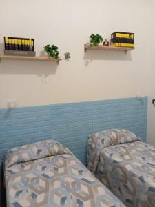 a room with two beds and shelves on the wall at A Za' Nella Avola in Avola