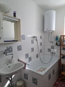 a bathroom with a sink and a bath tub at River View Apartment Gospic in Gospić
