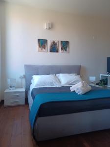 een bed in een slaapkamer met twee schilderijen aan de muur bij CASA MIA APARTMENT in Bologna