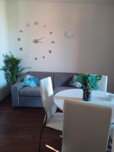 een woonkamer met een bank en een klok aan de muur bij CASA MIA APARTMENT in Bologna