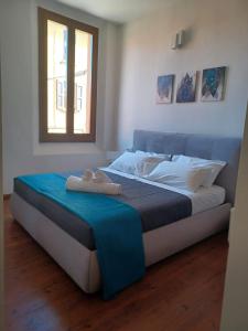 een bed met een blauwe deken en een raam bij CASA MIA APARTMENT in Bologna