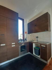 een keuken met houten kasten en een spoelbak bij CASA MIA APARTMENT in Bologna +8 foto's