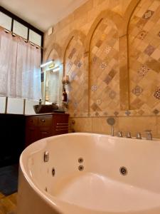 ein Bad mit einer weißen Badewanne in einem Zimmer in der Unterkunft La Maison des Templiers ~ Ostal Médiéval ~ Logis enchantés in Carcassonne