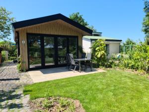 a patio with a table and chairs in a yard at Bungalowpark Mooyeveld in Egmond-Binnen