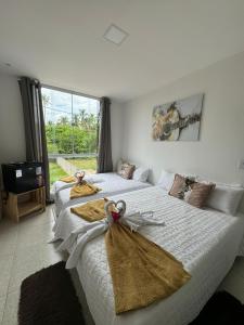 a bedroom with two beds with towels on them at Pousada Hércules Beach Paradise in Maragogi