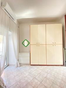 um quarto com armários brancos e uma janela em Euploia Apartment em Ischia